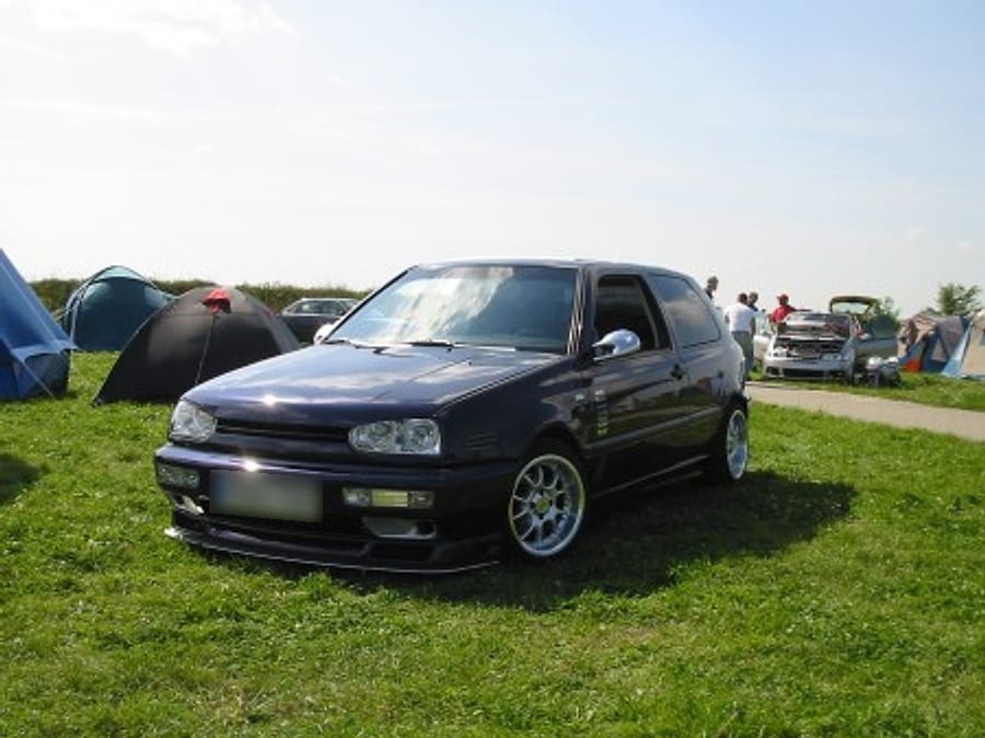 VW Golf MK3 on the grass at a car meet, tents in the background
