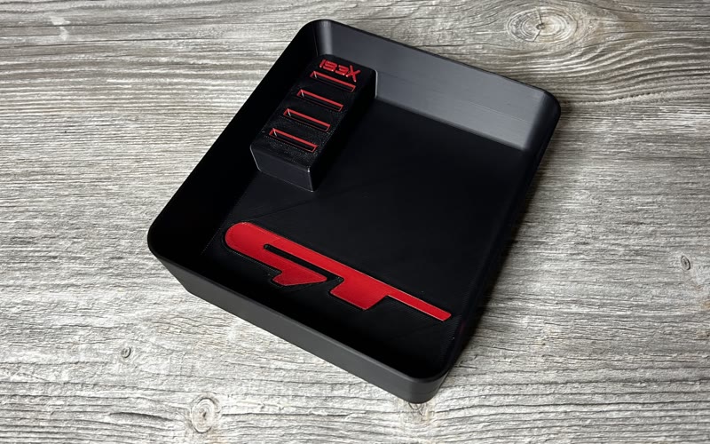Black centre console tray with a red GT logo and a coin holder with the IBEX logo
