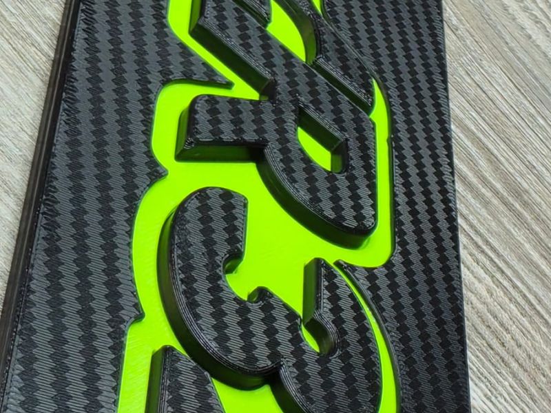 Macro shot of the carbon texture and the raised logo