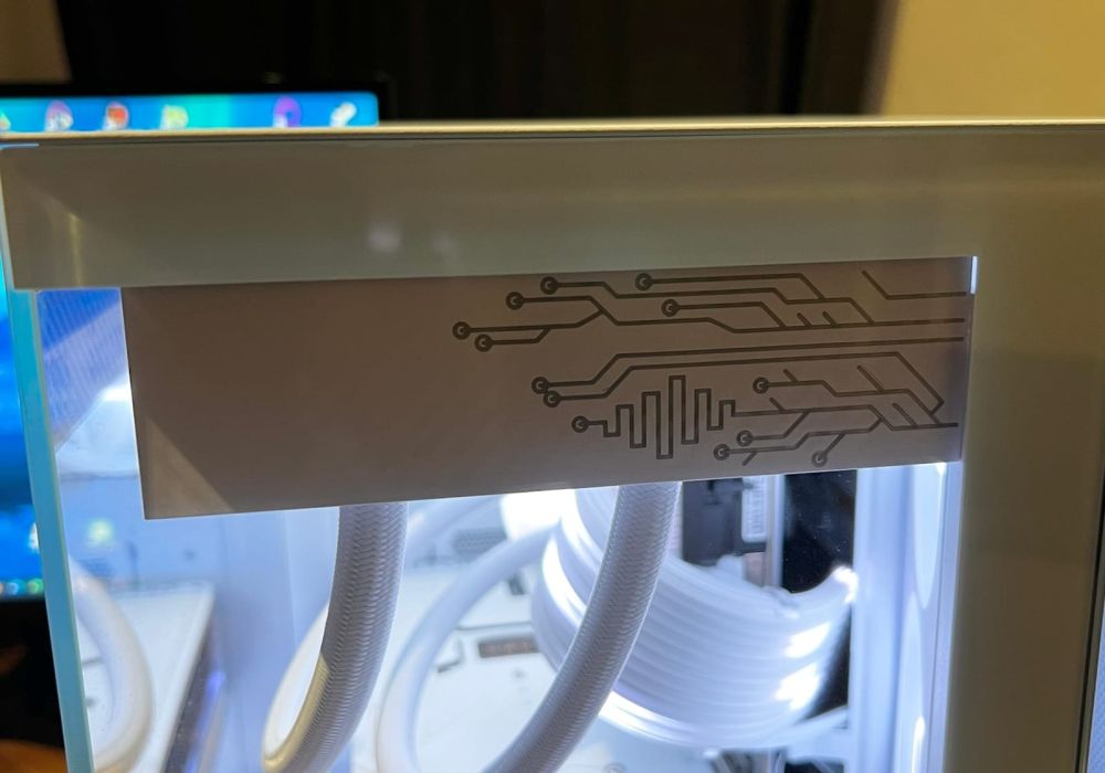 Front face of the white radiator cover with its hinted circuit pattern, fitted in the case