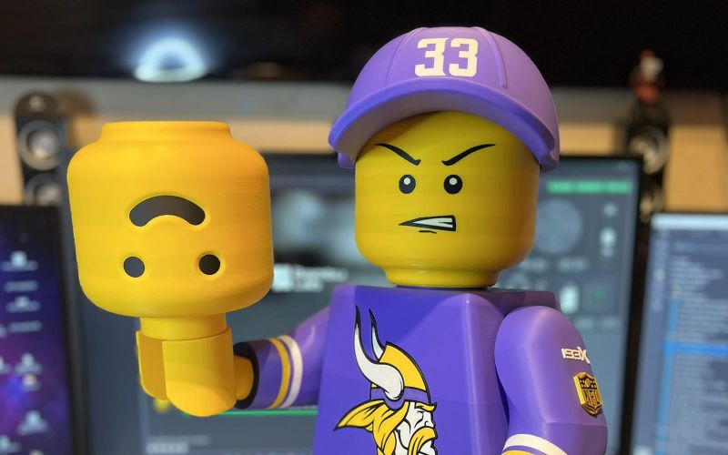 The grim-faced Brickman in his Vikings jersey and 33 cap, holding his friendly spare head