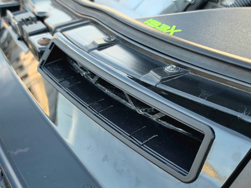 The plain intake slot above the grille before the insert