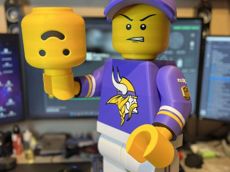 The grim-faced Brickman holding his friendly spare head