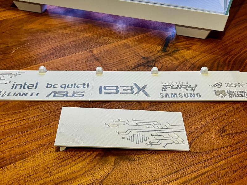 Both pieces of the white radiator cover: the side panel with the brand lettering and the front panel with the circuit pattern
