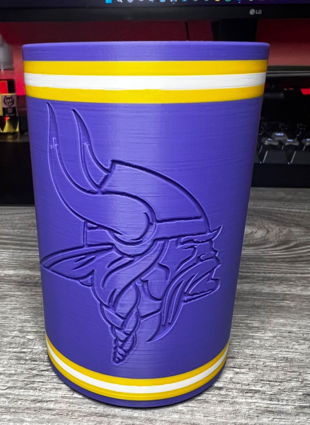 Purple can sleeve with gold stripes and the embossed Vikings logo