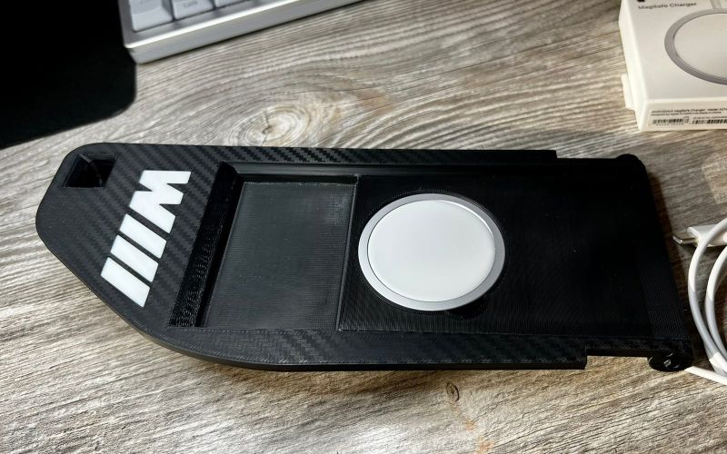 Black BMW E60 console insert with a white M logo and an Apple MagSafe charger
