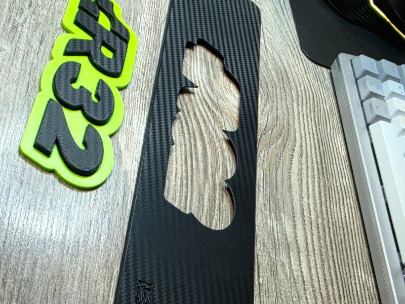 Carbon-texture plate with the logo cut-out and the green R32 logo