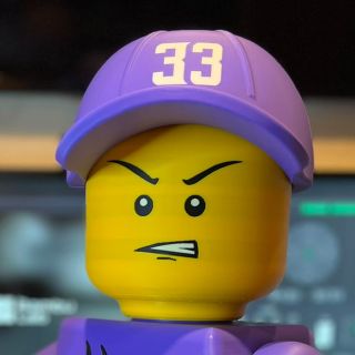 The Brickman game-day head with an angry face under the purple 33 cap